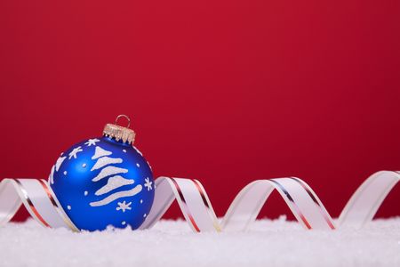 christmas colorful balls over the snow with a red background (selective focus)の写真素材