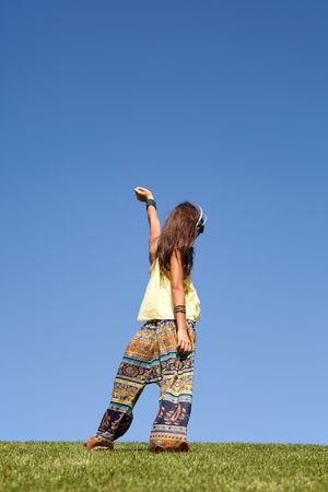 young female child listening to music at the fieldの写真素材