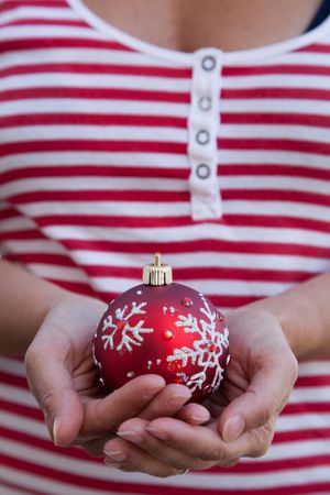 woman holding a red christmas ball (selective focus)の写真素材