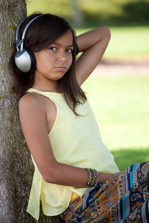 young child listening music at the parkの写真素材
