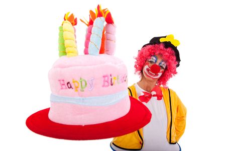 funny clown holding a birthday cake hat (isolated on white)の写真素材