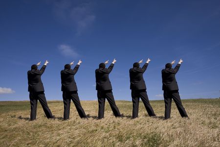 coordinated group of businessman pointing to the same sideの写真素材