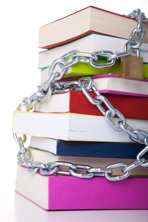 stack of colorful books protected with a chain (over a white background)の写真素材