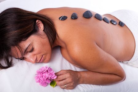 young beautiful woman in a spa enjoying a hot stone treatmentの写真素材