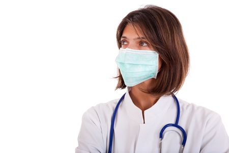 friendly woman doctor with a mask looking to the copy space (isolated on white)の写真素材