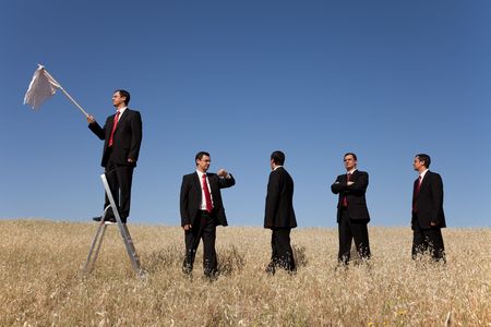 a group of businessman in the field getting in line for there time to surrenderingの写真素材
