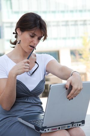 young businesswoman working with her laptop outdoorの写真素材