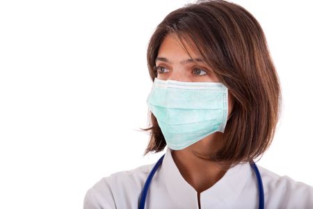 friendly woman doctor with a mask looking to the copy space (isolated on white)の写真素材
