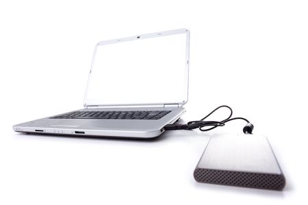 a silver laptop with an external disk with a white screen (isolated on white)の写真素材