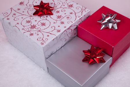 three christmas presents over white snow (selective focus)の写真素材