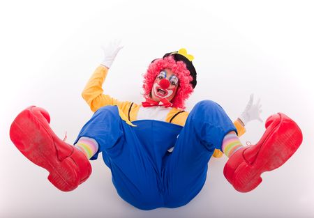funny circus clown falling on the floor (isolated on white)