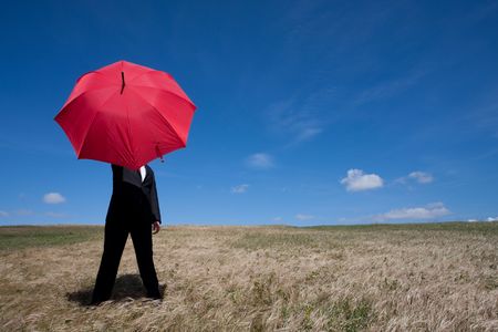 Businessman finding protection outside in the fieldの写真素材