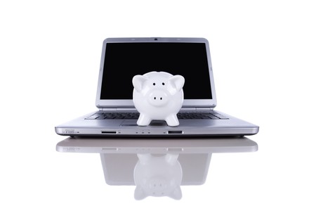 Piggybank over a modern laptop, the cost of technology and information (isolated on white)の写真素材
