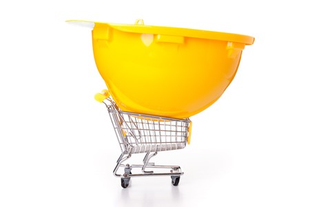 construction helmet over a shopping cart (isolated on white)の写真素材
