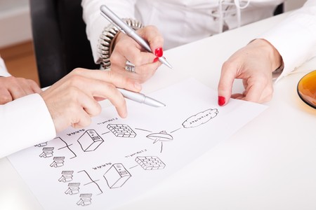 Detail of businesspeople hands working on a firewall schema (selective focus)の写真素材