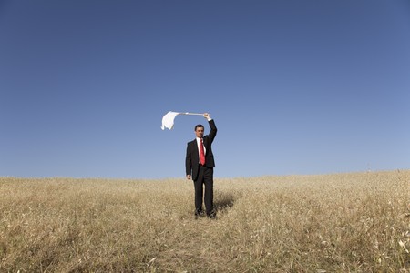 businessman asking for surrendering with a white flagの写真素材