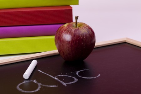 Back to school letters written on a blackboard with colorful books (selective focus)の写真素材