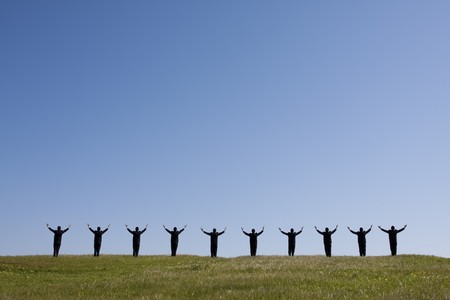 large group of businessman in the field with his arms outstretched