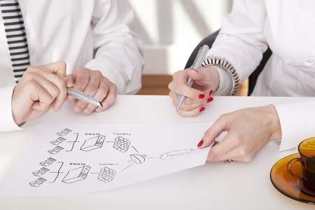 Detail of businesspeople hands working on a firewall schema (selective focus)