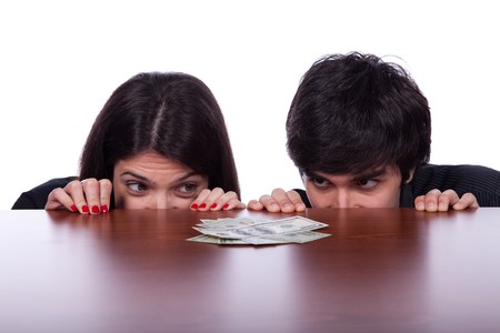 Men and woman looking to a lot of money over the tableの写真素材