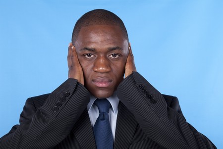 african businessman with hands covering his earsの写真素材