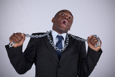 Powerful african businessman with a steel chain in his handsの写真素材