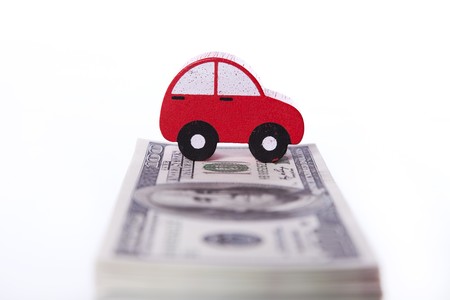 red car over a lot of dollar bills isolated on white  (selective focus)の写真素材