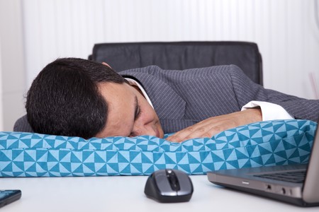 Exhausted businessman sleeping at his officeの写真素材