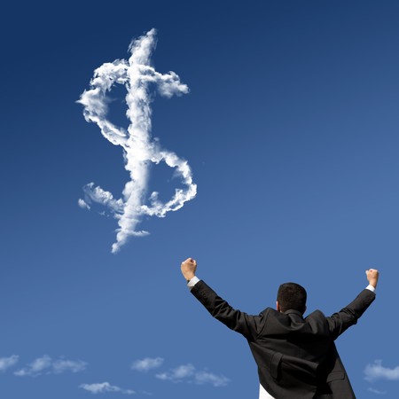 businessman showing his success at the field looking to a dollar symbol made of cloudsの写真素材
