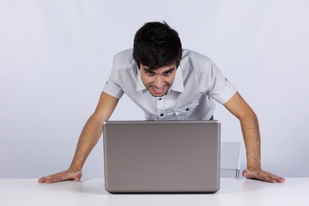 Young modern businessman satisfied looking to his laptop monitor at the office 