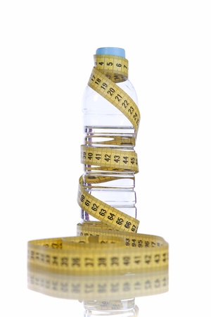 Bottle of healthy water wrapped with a yellow tape measureの写真素材