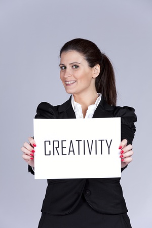 Happy businesswoman showing a paper with the word creativityの写真素材