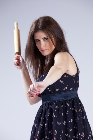 Fashion beautiful woman holding a rolling pinの写真素材