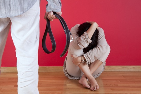 Men threating and beating his wife at home with a belt