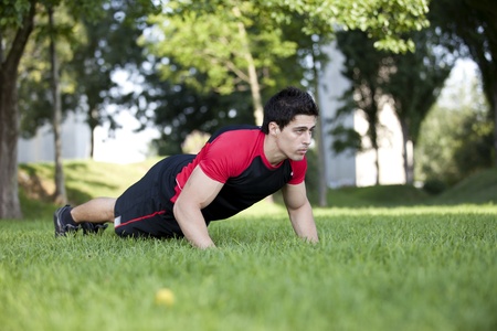 Athlete man at the city park making some pushup