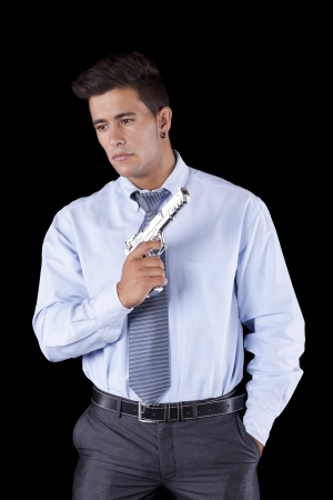 Powerful businessman with a gun (isolated on black)の写真素材