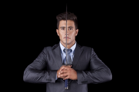 Powerful businessman holding a ninja sword (isolated on black)の写真素材