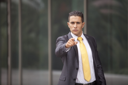 Businessman next to his office pointing to youの写真素材