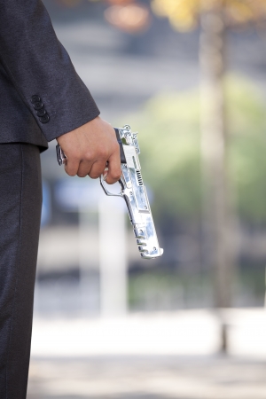 Detail of a hand holding a gunの写真素材