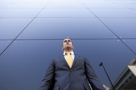 Confident young businessman next to his office buildingの写真素材