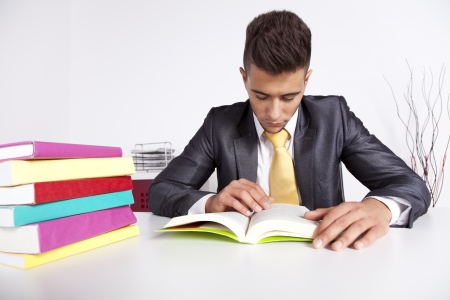 Handsome businessman reading a book in his officeの写真素材