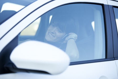 Woman in risk driving holding and talking at her cellphoneの写真素材