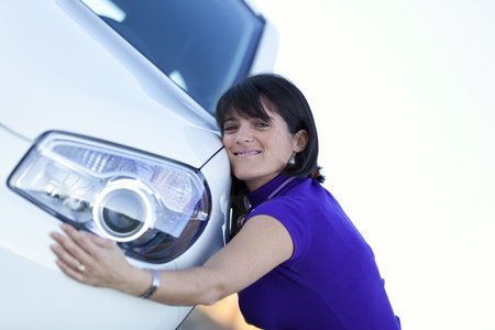 Beautiful woman embracing her new carの写真素材