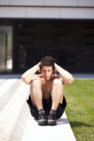 Athlete man at the city making some abdominalsの写真素材