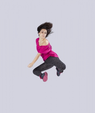 Woman dancer jumping isolated on gray (some motion blur)の写真素材