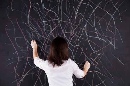 Stressed woman writing in the chalkboard lots of crazy linesの写真素材
