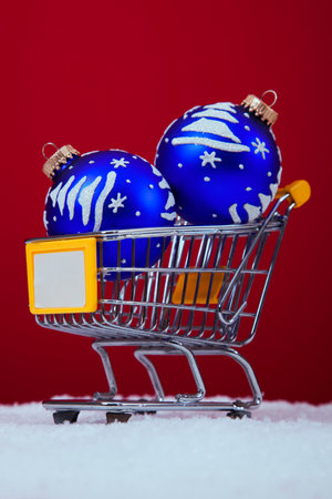 Christmas balls in a shopping cart over a red backgroundの写真素材