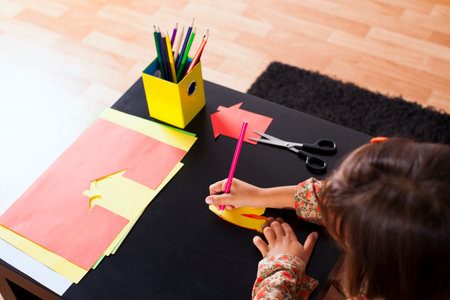 Little girl at her home drawing with a pencilの写真素材