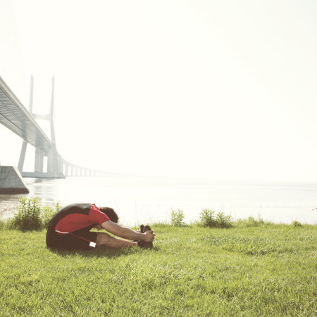 Athlete at the city park warming up and stretchingの写真素材