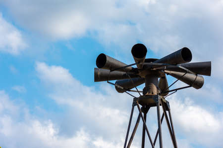 Old multidirectional emergency siren attached to a steel pylon. Concepts of urgent crisis communication, alarm and dangerの写真素材